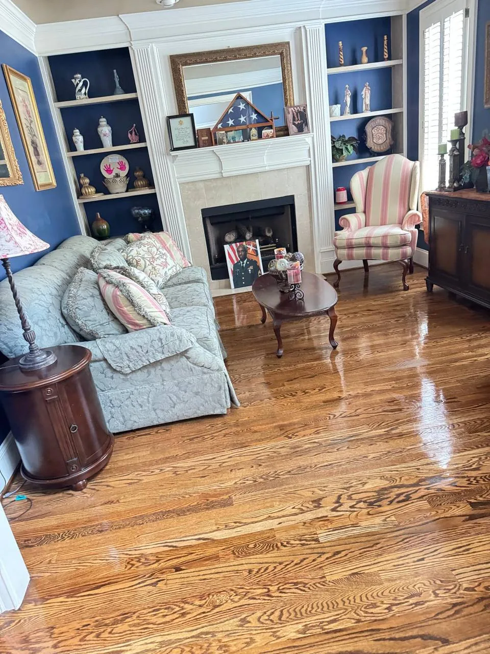 Professional cleaner tidying a bright living room for a Raynham, MA home
